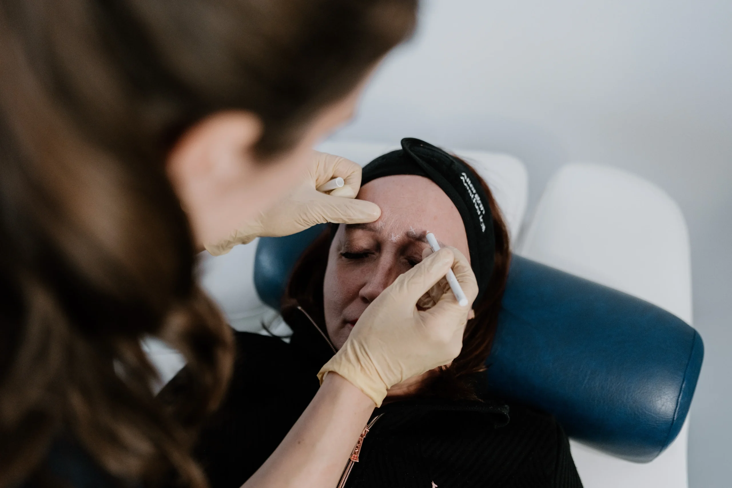 Dr. Katharina Udvari, Ästhetische Medizinerin bei der Behandlung einer Patientin im Gesicht.